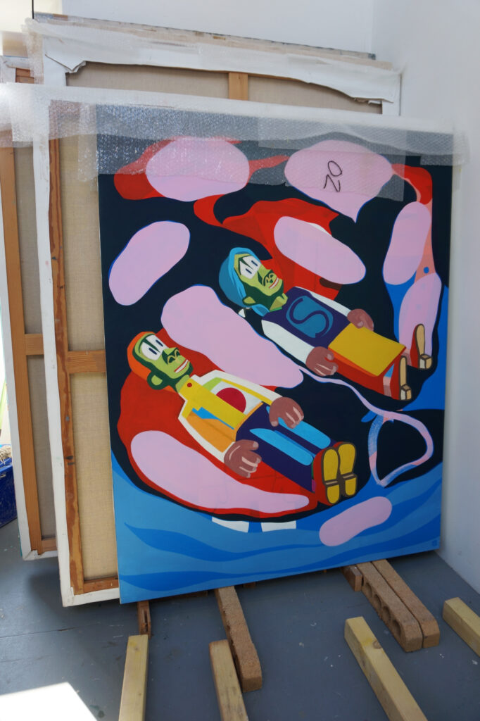 Ici on peut voir dans une peinture de Benoit Andro dans l’atelier deux personnages, des gisants, allongés géométrisés sur le dos aux couleurs vives