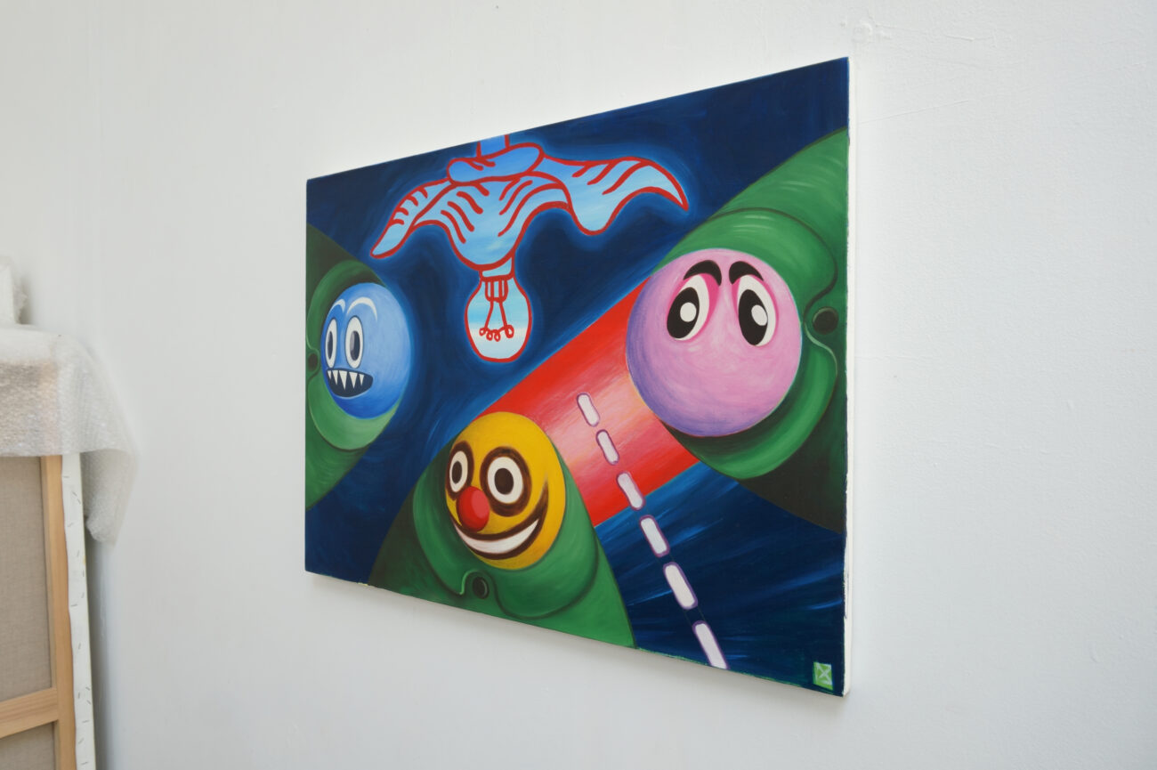 Une peinture à l'huile de Benoit Andro avec trois têtes géométrisées bien rondes accrochée dans l'atelier.