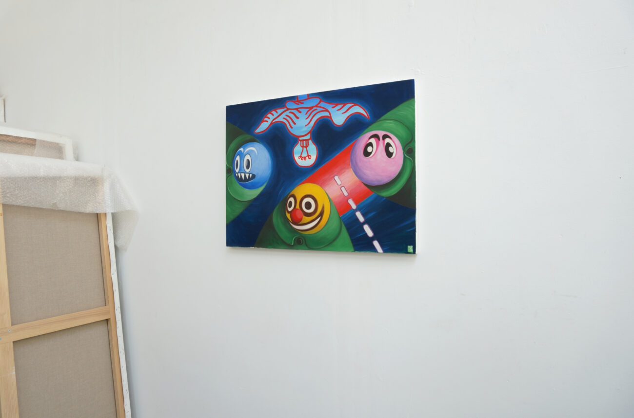 Une peinture à l'huile de Benoit Andro avec trois têtes géométrisées bien rondes accrochée dans l'atelier.