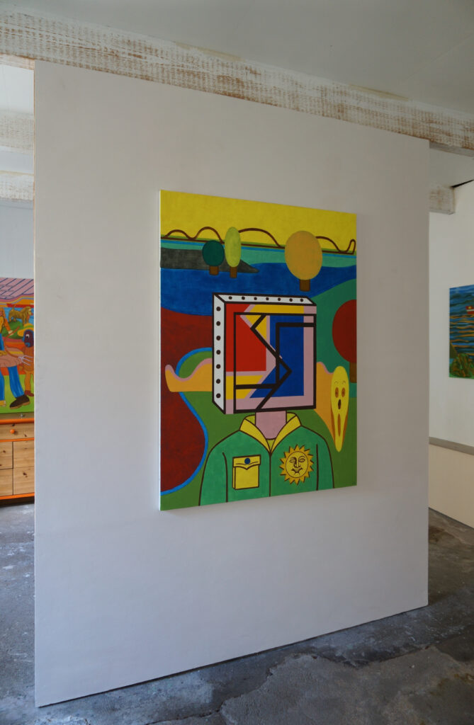 Au mur de l'atelier de benoit andro on peut voir une peinture qui représente un personnage frontal à la tête carrée avec paysage géométrisé derrière